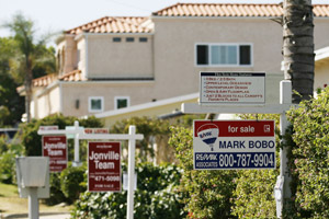 Real estate signs advertise the sale of three homes in a row in Encinitas, Calif. Thursday, July 13, 2006. California's housing slowdown hits a dubious milestone, with year-over-year prices in San Diego County falling in June for the first time since the state housing boom began there six years ago. It's the first major California real estate market to see its median home price fall below year-ago levels. (AP Photo/Denis Poroy)
