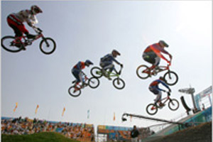 Riders clear a jump at the BMX course in Beijing, where the discipline will make its Olympic debut in August. (© AP Images)