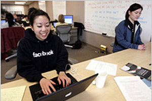 Facebook.com employee Ginnie Chan, left, works at Facebook headquarters in Palo Alto, California. (© AP Images)