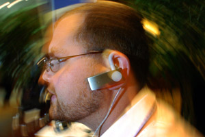 Andrew Einaudi, Director of Product Development, shows the new Jawbone mobile phone headset during the Demomobile Technology show in San Diego on Friday, September 10, 2004. The headset filters out background noise as well as enhances incoming audio.(AP photo/Sandy Huffaker)